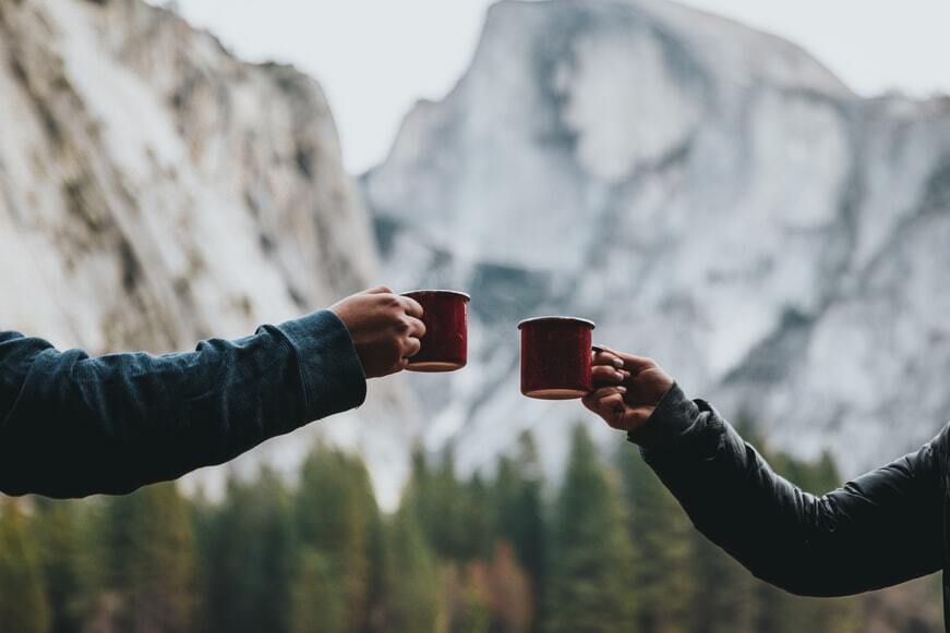 two people holding red mugs|
