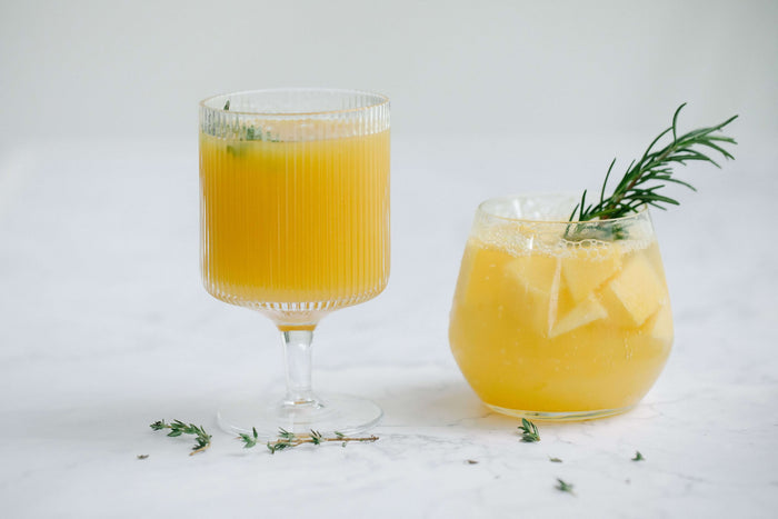 Citrus juices with fresh herbs served in glasses for non-alcoholic mixology