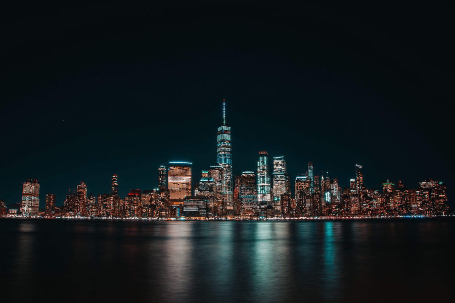 illuminated cityscape of Jersey City at night|stainless spoon with green kratom powder