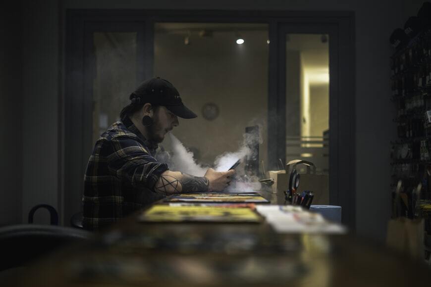 man seating at a table vaping|