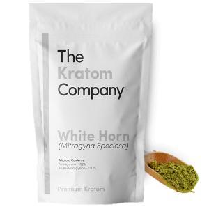 A packet of white Horn kratom powder, with some powder on a wooden vessel.