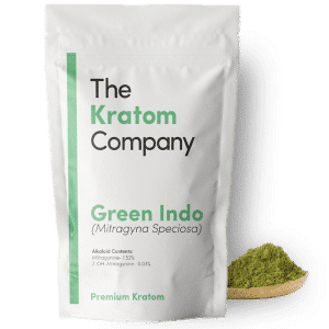 A packet of green Indo kratom powder, with some powder on a wooden vessel.