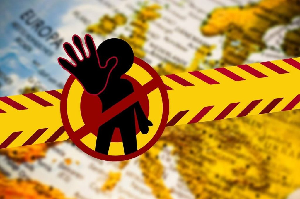 Concept image of yellow tape and a “stop” hand over European map