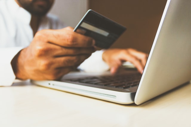 Man paying with a credit card on a laptop