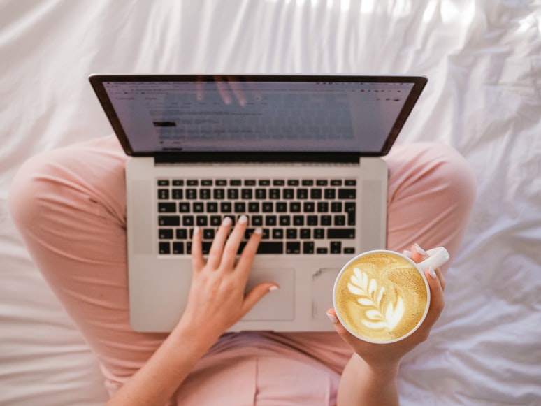 woman working on a laptop and drinking coffee