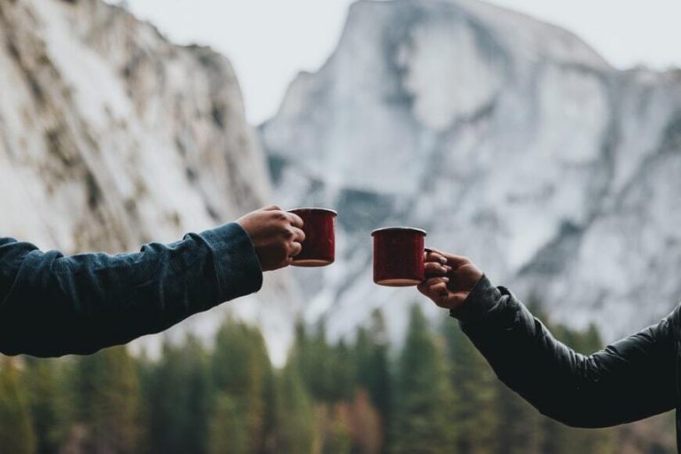 two people holding red mugs