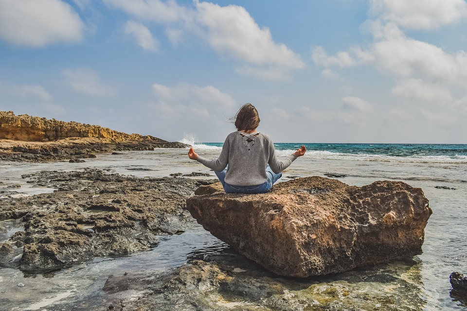 woman meditating at the beach