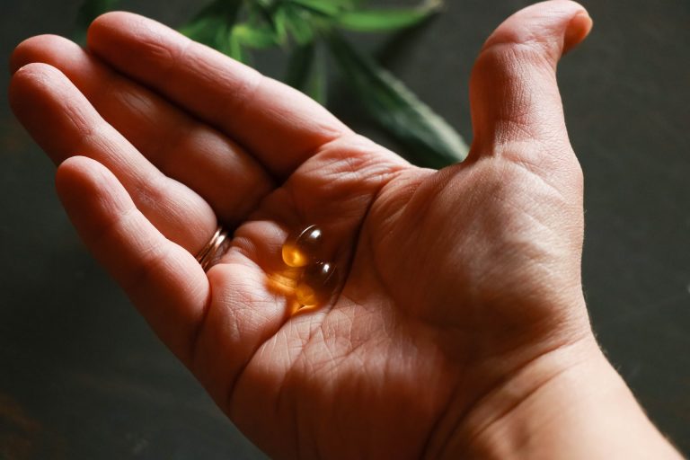 Two liquid kratom capsules in palm of hand