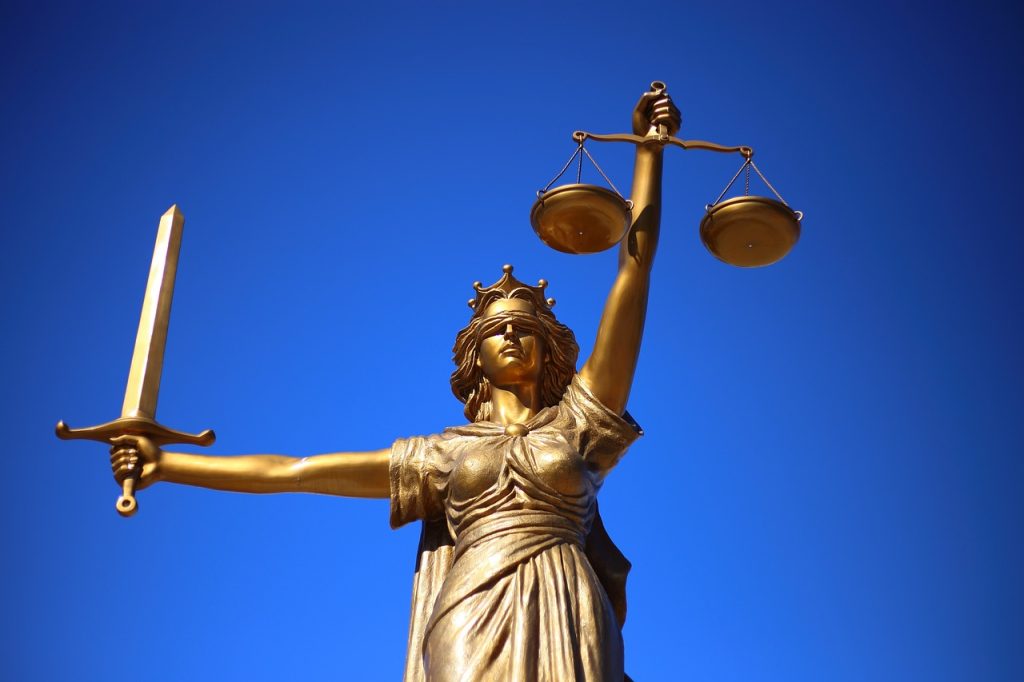 Statue of Lady Justice holding sword and scales against a blue sky
