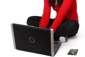 Woman in red sweater shopping online with laptop