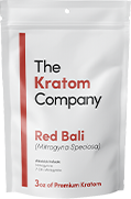 A packet of red Bali kratom powder, with some powder on a wooden vessel.