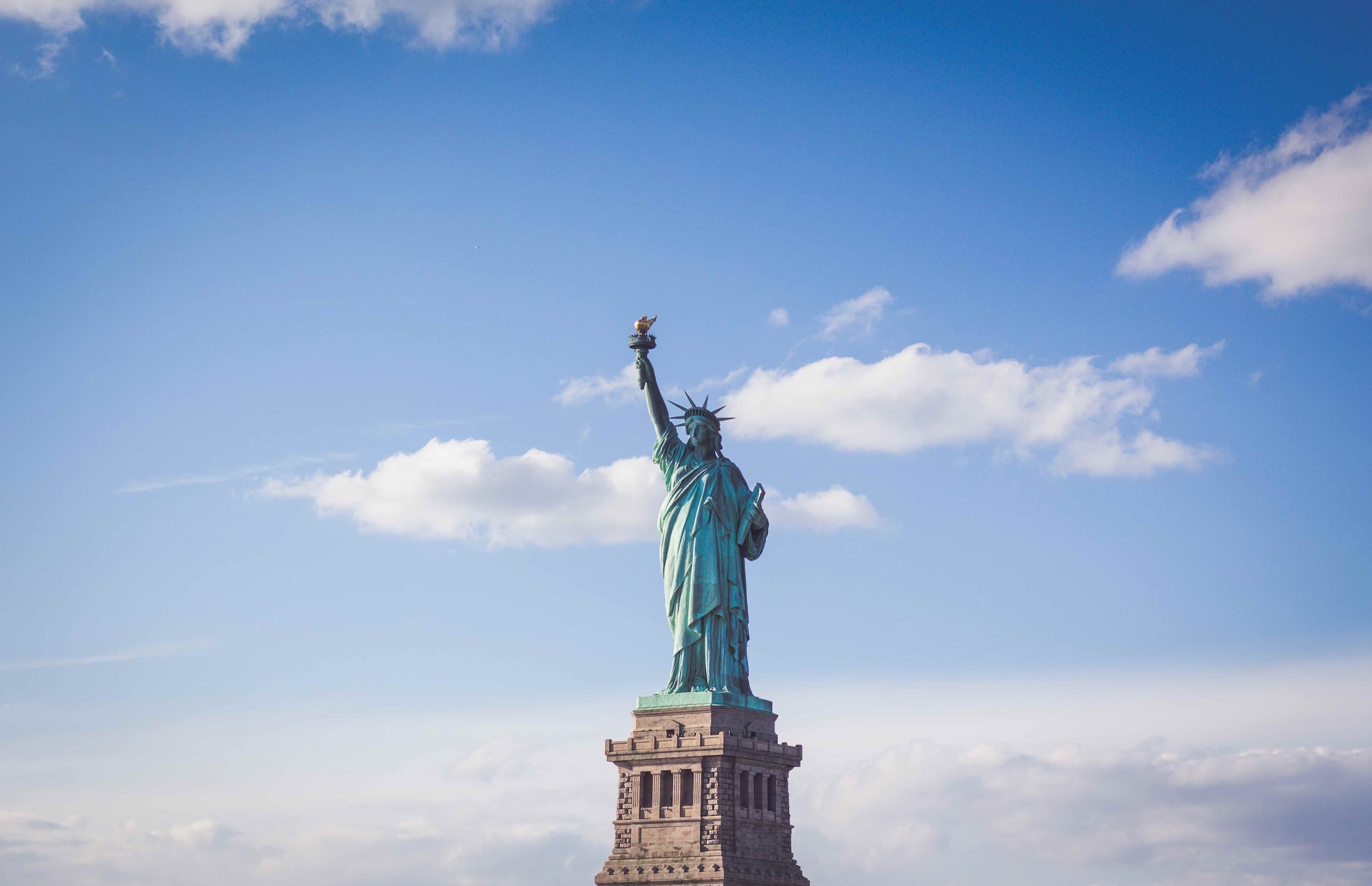 Statue of Liberty against a blue cloudy sky