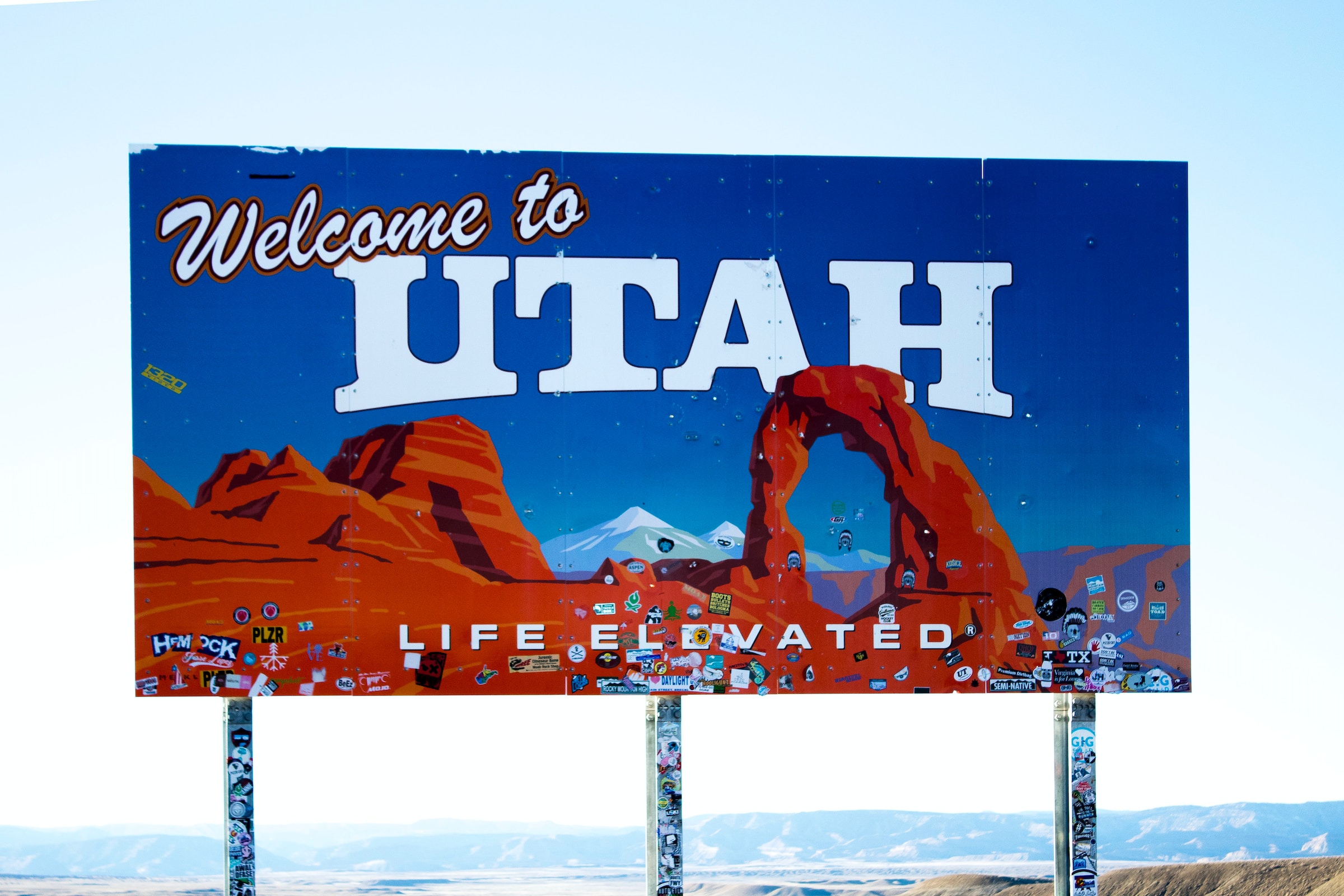 Welcome to Utah billboard with red rocks on the side of a highway