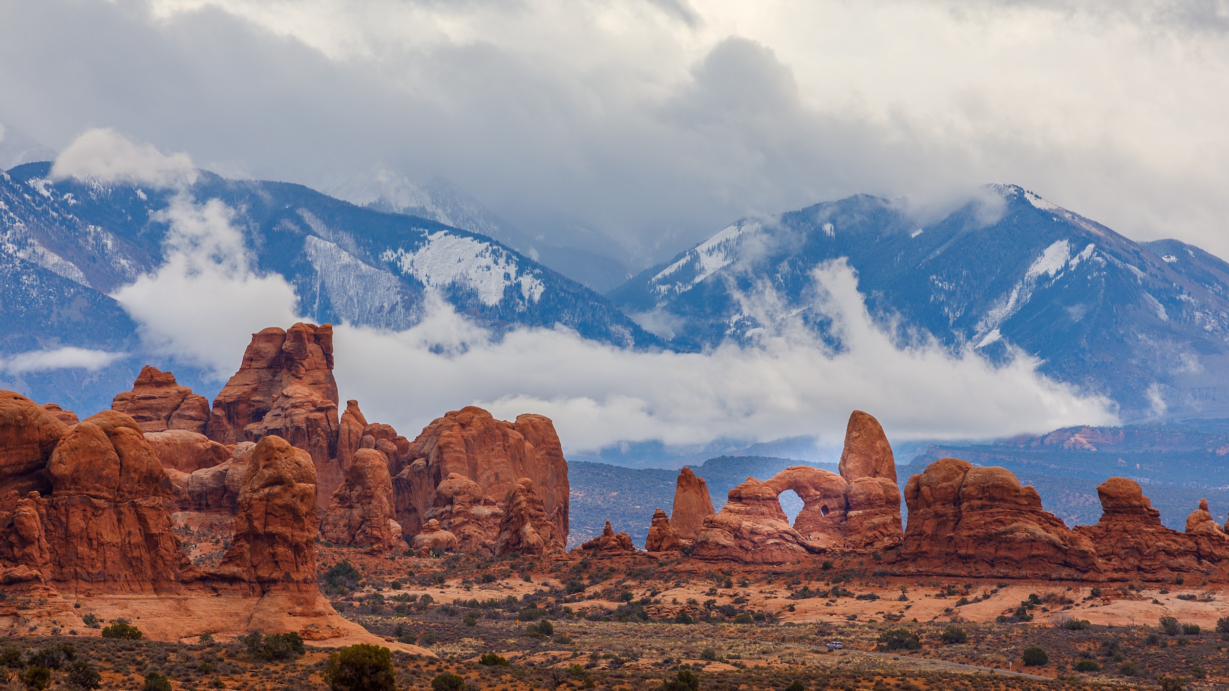 Towering red rocks against a mountain landscape in Moab, Utah